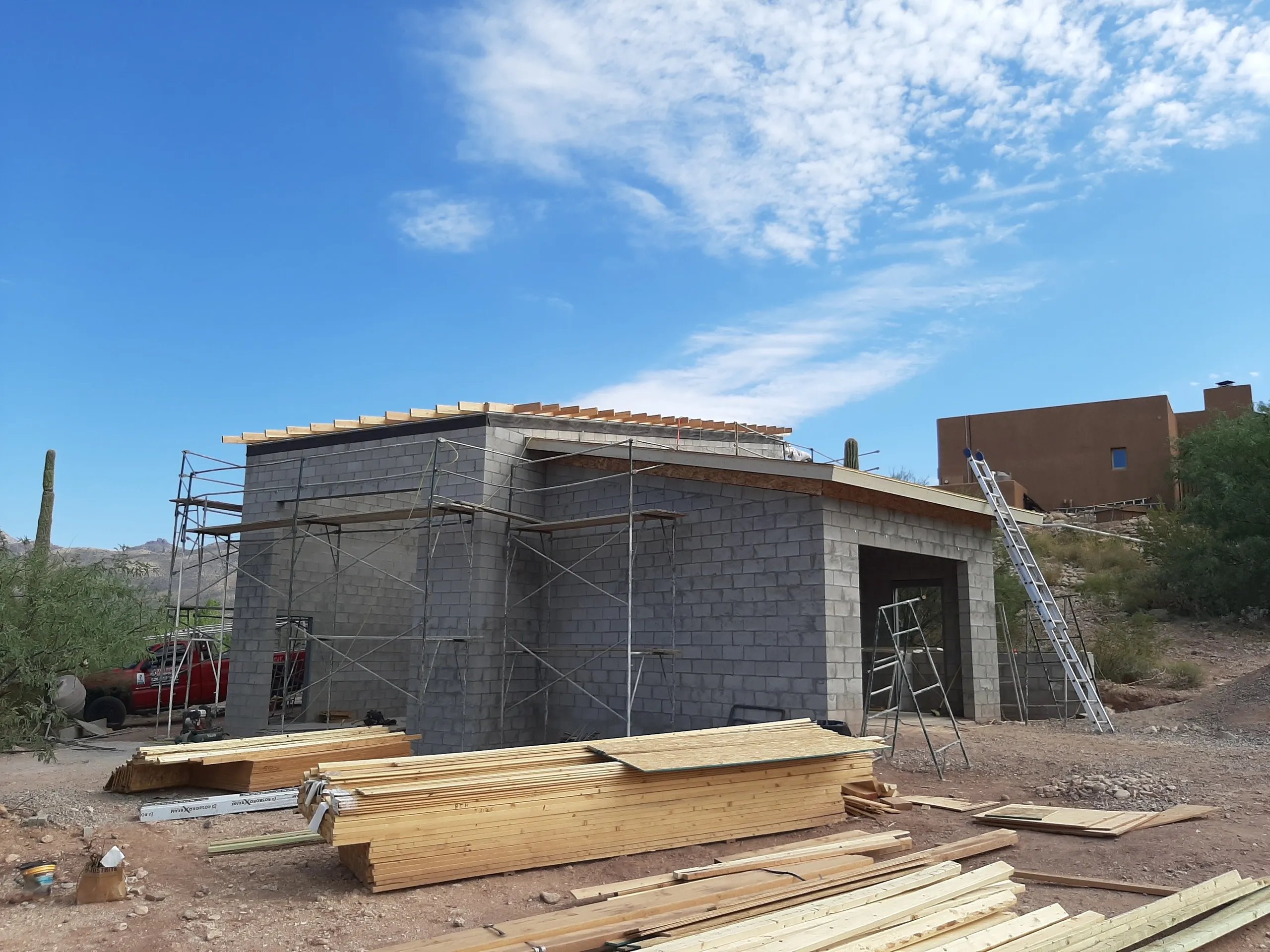Building construction site with concrete block structure and wooden lumber