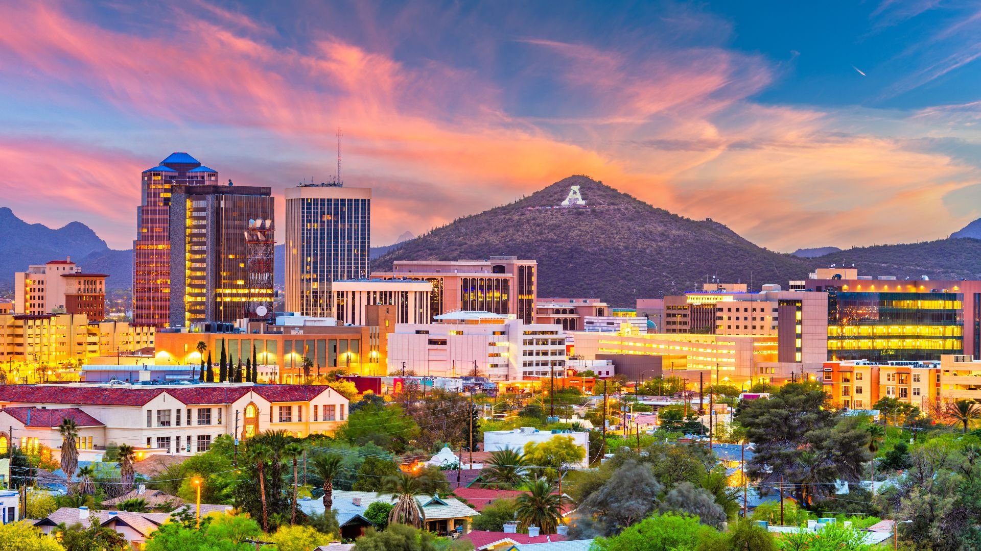 Tucson, Arizona skyline with colorful buildings and mountain at sunset