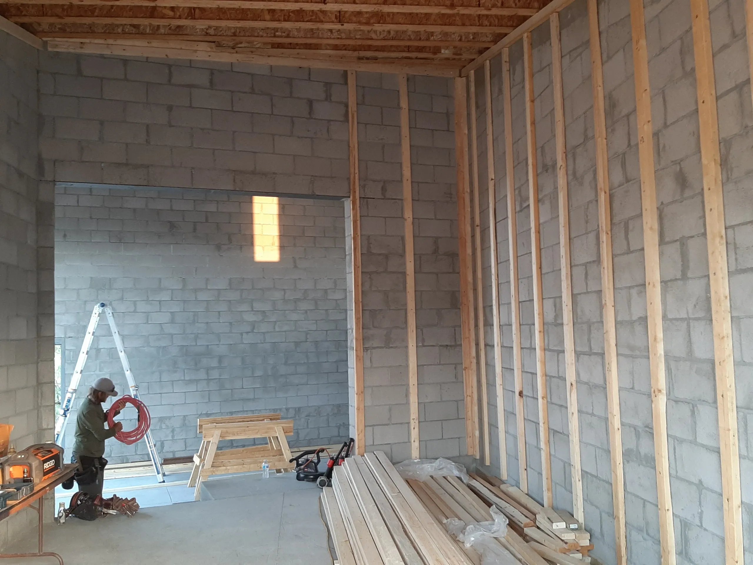 Construction site with wooden framing, concrete walls, and building materials