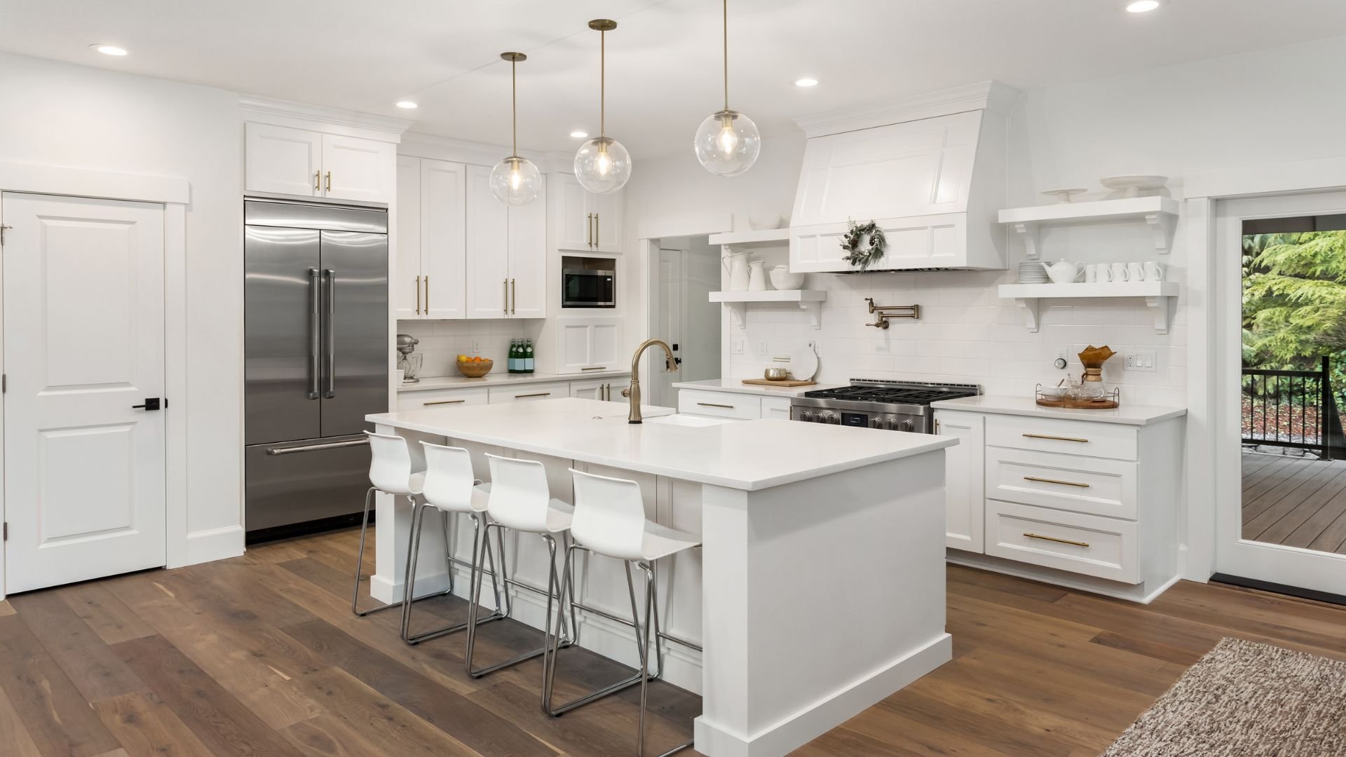 Modern white kitchen with island, pendant lights, and wooden floors