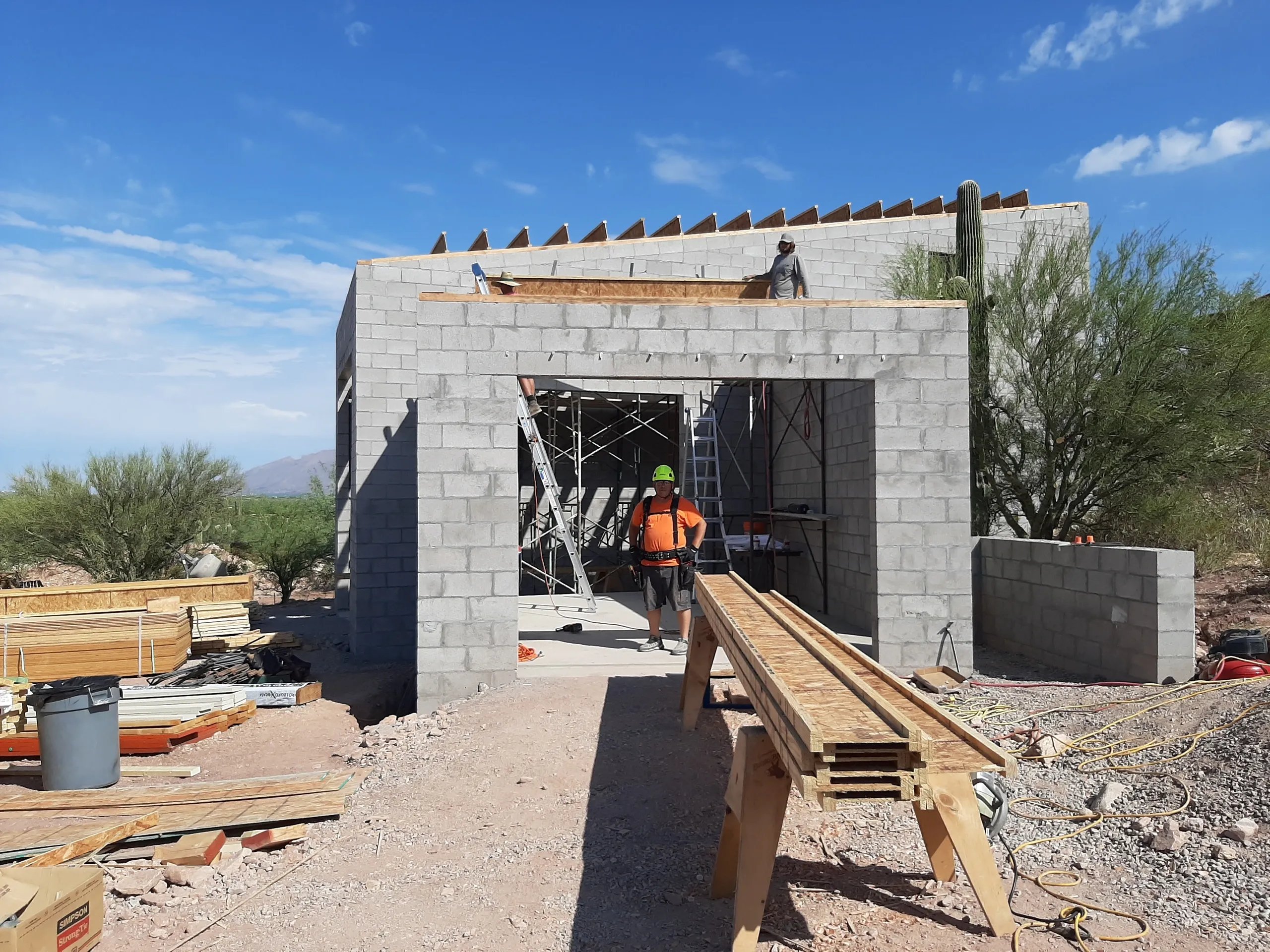 Construction workers building concrete block structure in desert landscape